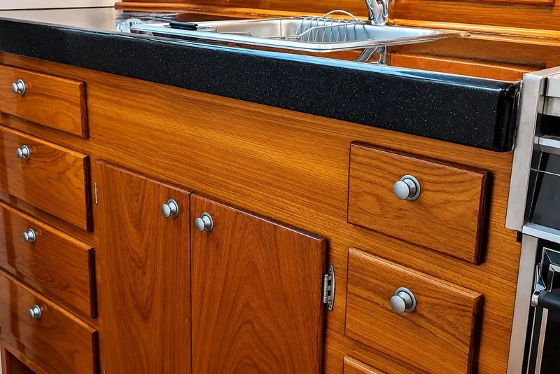 Slide: The Image of Wooden cabinetry with black countertop in a 1981 Bertram 46.6 yacht kitchen. - 8