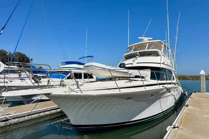 Slide: The Image of 1981 Bertram 46.6 yacht docked at marina under clear blue sky. - 1