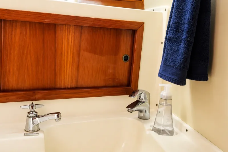 Slide: The Image of Bathroom sink area on a 1981 Bertram 46.6 yacht with wooden cabinet. - 14