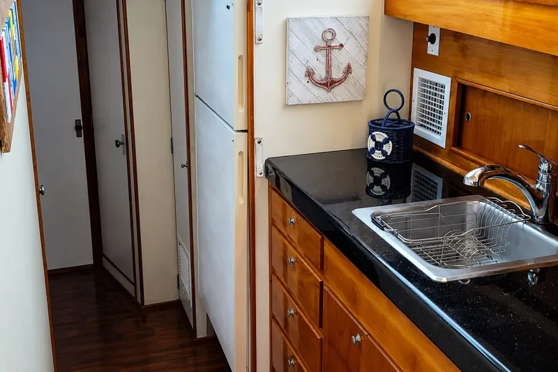 Slide: The Image of Interior of 1981 Bertram 46.6 yacht kitchen with wooden cabinets and stainless steel sink. - 12