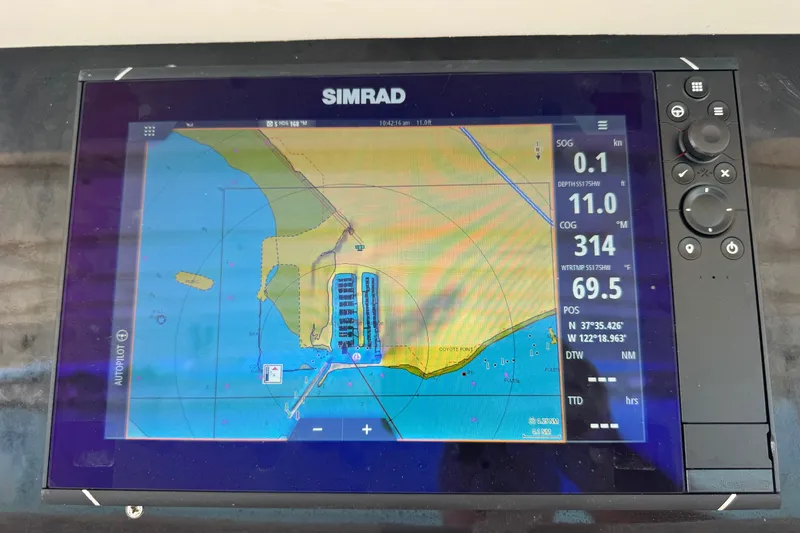 Slide: The Image of Simrad navigation display on a 1981 Bertram 46.6 yacht, showing coastal map and coordinates. - 25