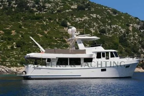 Slide: The Image of 2011 Ocean Alexander 60 Trawler yacht anchored near a scenic, rocky coastline. - 5