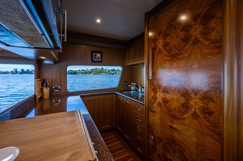 Slide: The Image of Luxurious kitchen interior of 2011 Ocean Alexander 60 Trawler with wood finish and scenic window view. - 80
