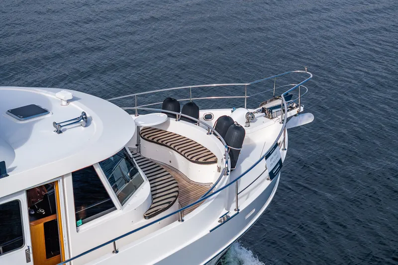 Slide: The Image of 2011 Ocean Alexander 60 Trawler cruising on open water, showcasing sleek design and deck seating. - 33