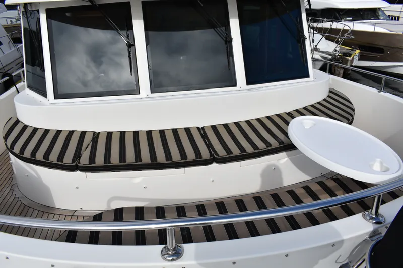 Slide: The Image of Ocean Alexander 60 Trawler 2011 with striped seating and round table on deck. - 35