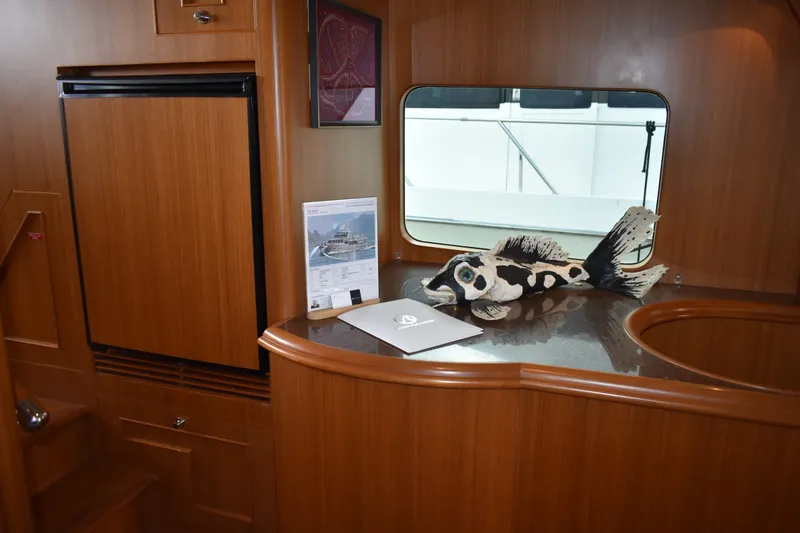 Slide: The Image of Interior of 2011 Ocean Alexander 60 Trawler with wooden cabinetry and decorative fish sculpture. - 82