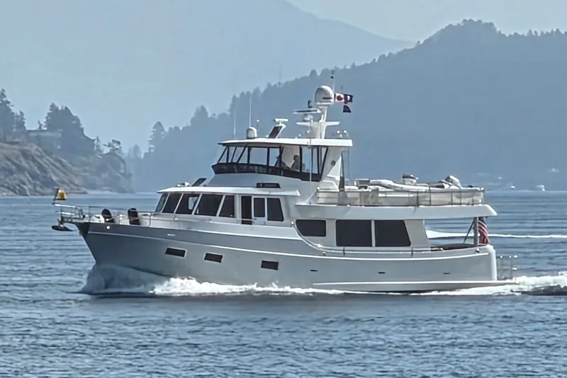 The Image of Ocean Alexander 60 Trawler 2011 cruising on a scenic waterway with mountainous backdrop. - 0