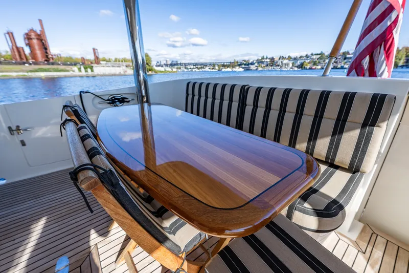 Slide: The Image of Luxurious 2011 Ocean Alexander 60 Trawler deck with elegant wood table and striped seating. - 40