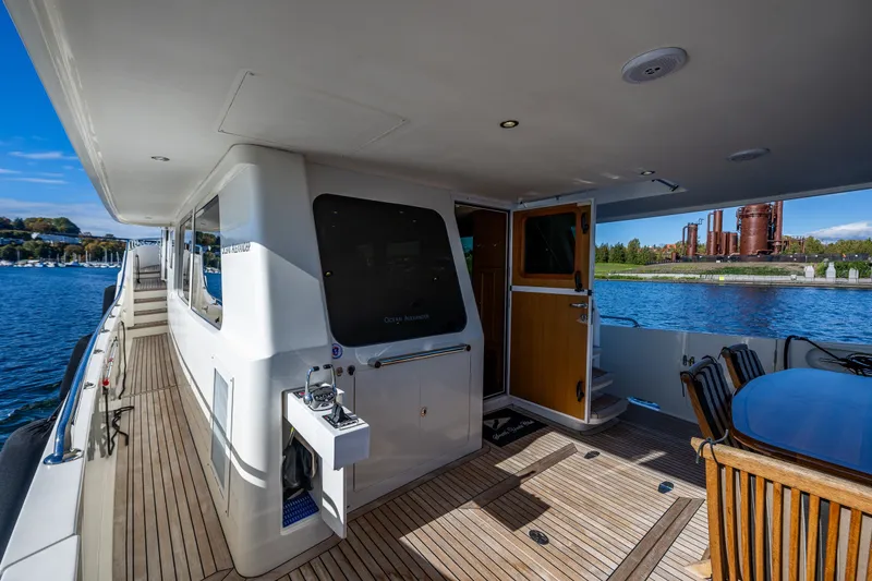 Slide: The Image of 2011 Ocean Alexander 60 Trawler yacht deck with wooden flooring and outdoor seating. - 36