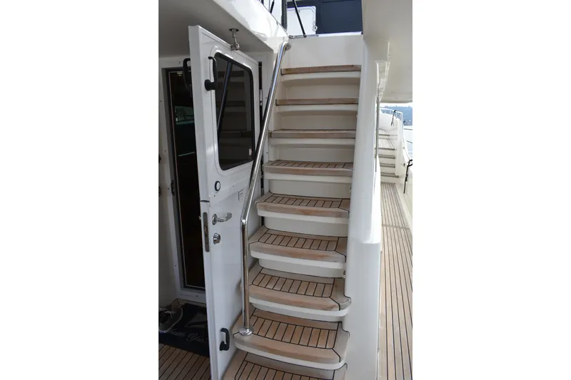 Slide: The Image of Staircase on 2011 Ocean Alexander 60 Trawler yacht with teak steps and metal railing. - 41
