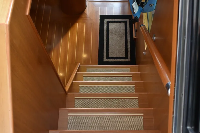 Slide: The Image of A wooden staircase with carpet runners leads into the boat's interior. - 60