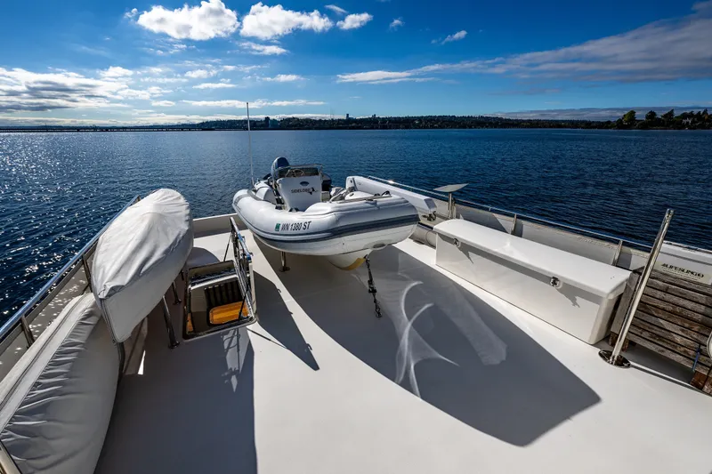 Slide: The Image of Ocean Alexander 60 Trawler 2011 deck with dinghy, overlooking serene water and blue sky. - 45