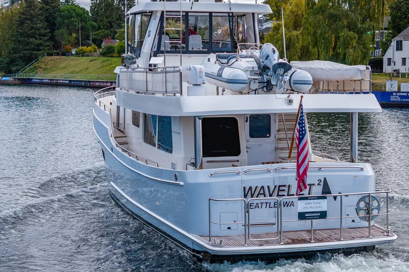 Slide: The Image of 2011 Ocean Alexander 60 Trawler cruising on a scenic waterway with American flag. - 16