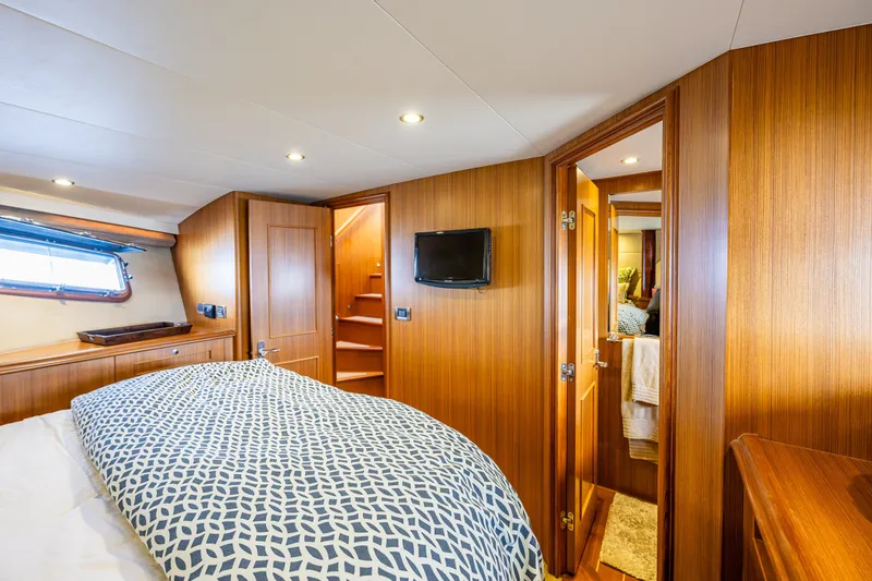 Slide: The Image of Luxurious cabin interior of 2011 Ocean Alexander 60 Trawler with wood paneling and cozy bedding. - 96