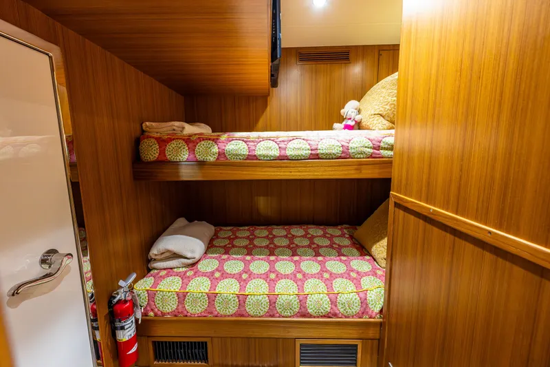 Slide: The Image of Bunk beds in 2011 Ocean Alexander 60 Trawler cabin with colorful bedding and wooden interior. - 105