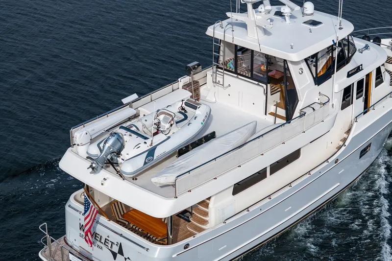 Slide: The Image of 2011 Ocean Alexander 60 Trawler cruising with a small boat on deck. - 31