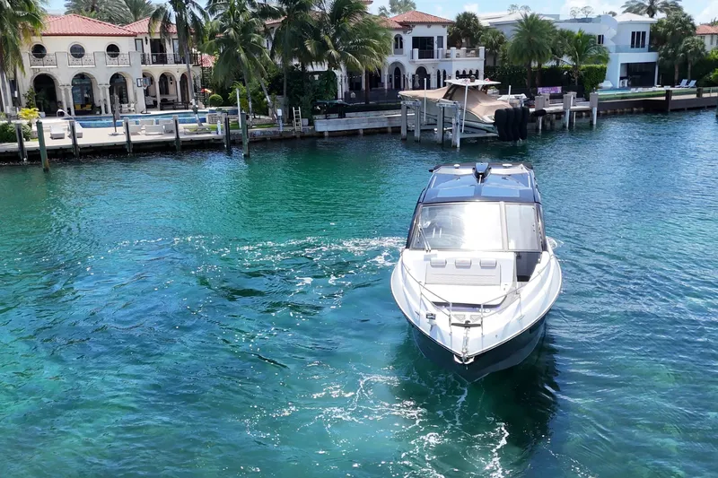Slide: The Image of Luxury Granfort 370 GTX yacht cruising in clear blue waters near waterfront villas, 2027 model. - 8