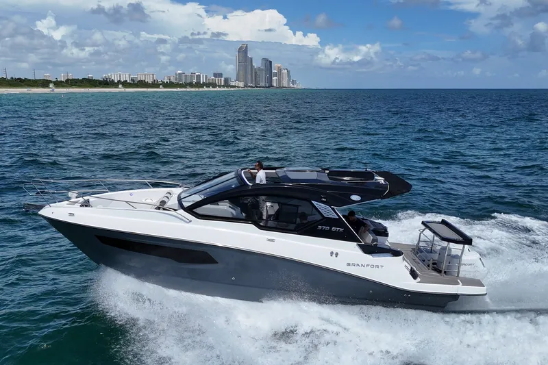 Slide: The Image of Granfort 370 GTX yacht cruising near a city skyline, 2027 model. - 0
