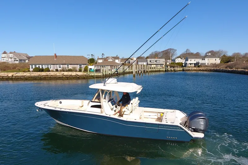Slide: The Image of 2022 Grady-White Canyon 326 boat cruising in a scenic coastal area. - 8