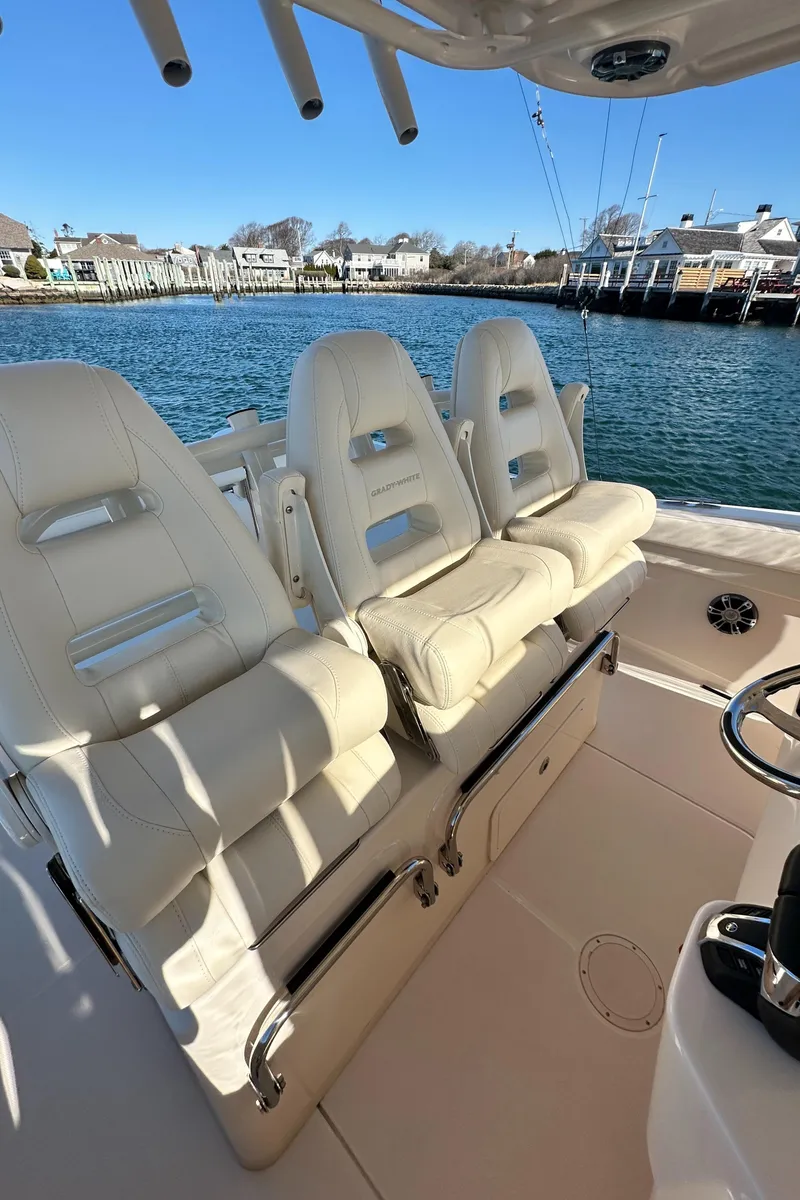 Slide: The Image of 2022 Grady-White Canyon 326 boat with luxurious seating, docked by the waterfront. - 42