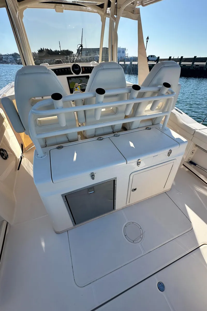 Slide: The Image of 2022 Grady-White Canyon 326 boat interior with seating and storage, docked by the water. - 38