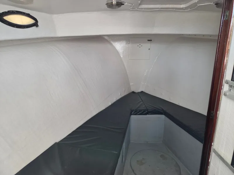 Slide: The Image of Interior view of a cabin with cushioned seating and porthole, in a 1998 BHM boat. - 15