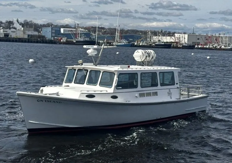 The Image of A white BHM boat, model "Finished By Wilbur Yachts" from 1998, cruising on calm waters. - 1