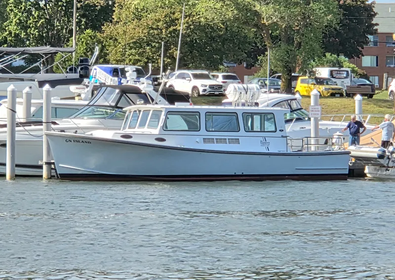 Slide: The Image of A 1998 BHM boat, finished by Wilbur Yachts, docked at a busy marina. - 1