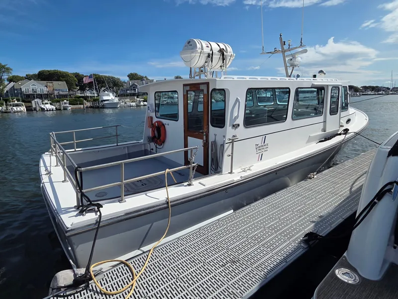 Slide: The Image of A 1998 BHM boat finished by Wilbur Yachts is docked. It features a spacious deck. - 2