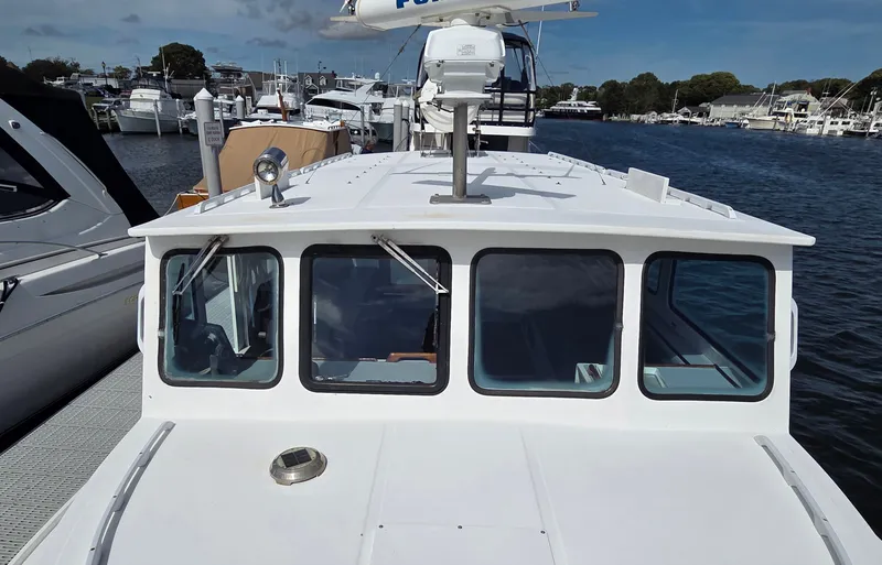 Slide: The Image of A white boat with large windows is docked in a marina, surrounded by other boats. - 7