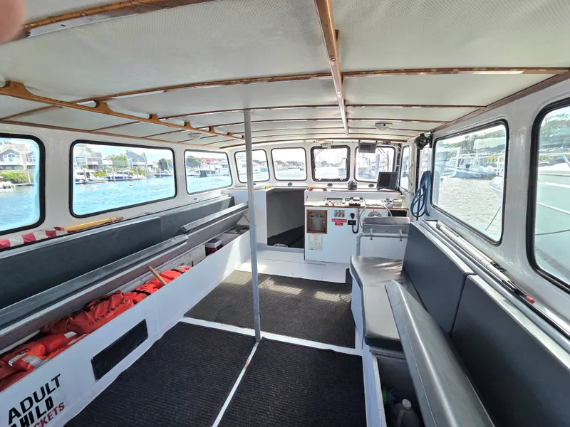 Slide: The Image of Interior of a 1998 BHM boat finished by Wilbur Yachts, featuring benches and windows. - 5