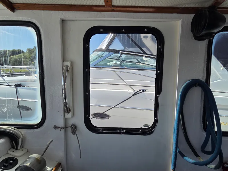 Slide: The Image of Interior view of a boat with windows and a door looking out at another boat. - 11
