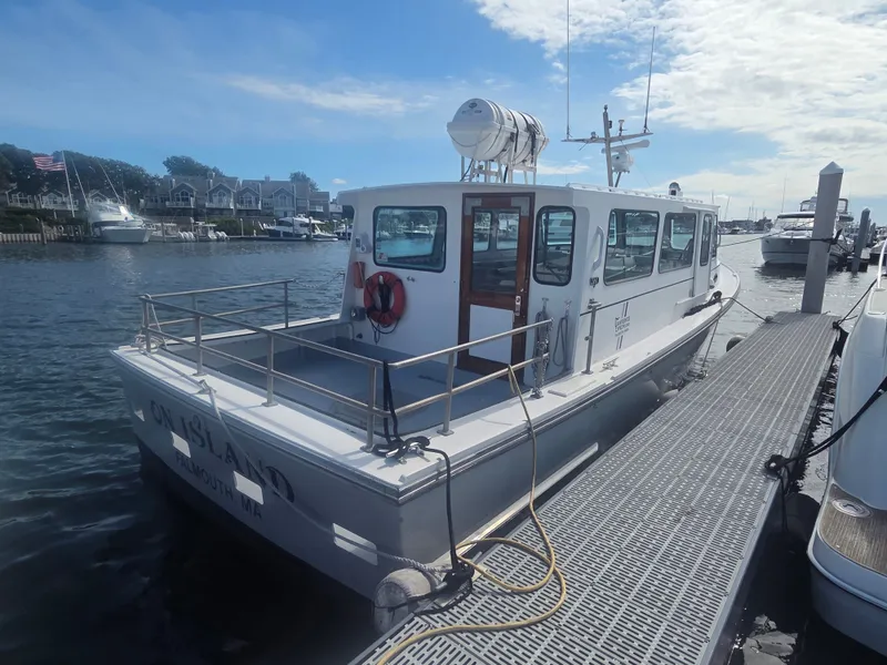 Slide: The Image of A 1998 BHM boat, finished by Wilbur Yachts, docked. It features a white cabin. - 19