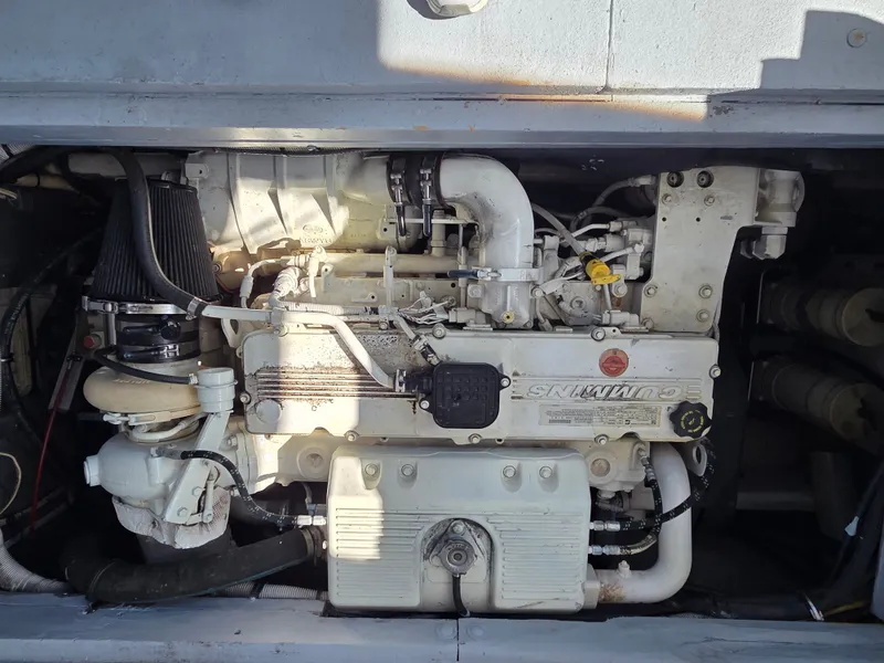 Slide: The Image of An engine compartment featuring a Cummins engine in a 1998 BHM boat. - 12