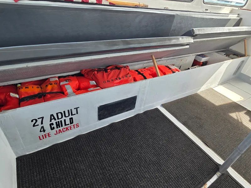 Slide: The Image of Interior of a boat with 27 adult and 4 child life jackets stored in a compartment. - 6