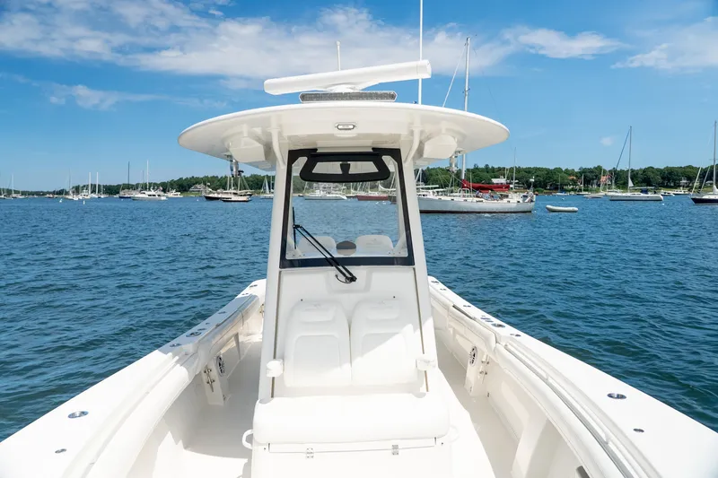 Slide: The Image of 2021 Regulator 28 Forward Seating boat on calm water with sailboats in the background. - 16