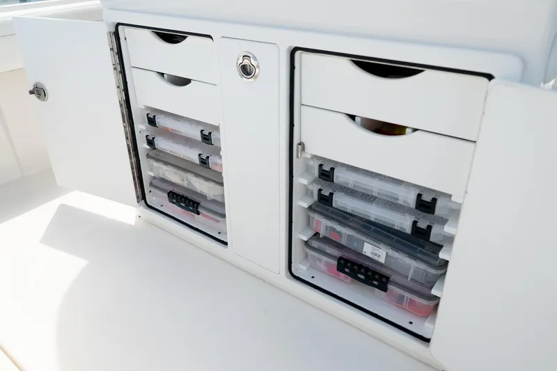 Slide: The Image of Storage compartments on a 2021 Regulator 28 Forward Seating boat, featuring organized tackle boxes. - 14