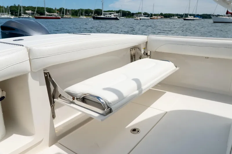 Slide: The Image of 2021 Regulator 28 Forward Seating boat with foldable seat, docked in a marina. - 15