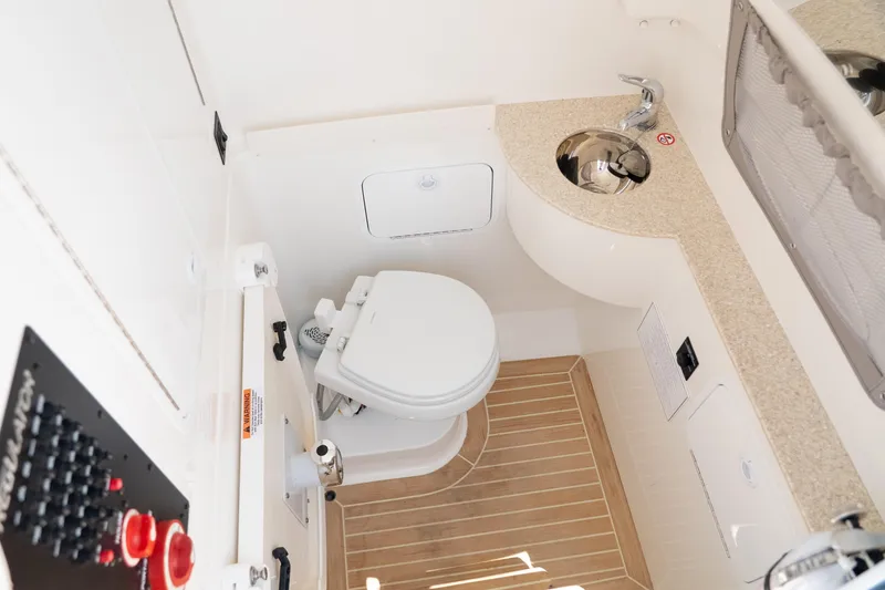 Slide: The Image of 2021 Regulator 28 Forward Seating boat bathroom with toilet and sink. - 21