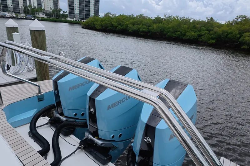 Slide: The Image of Schaefer V44 2025 boat with triple Mercury outboard engines docked by a river. - 37