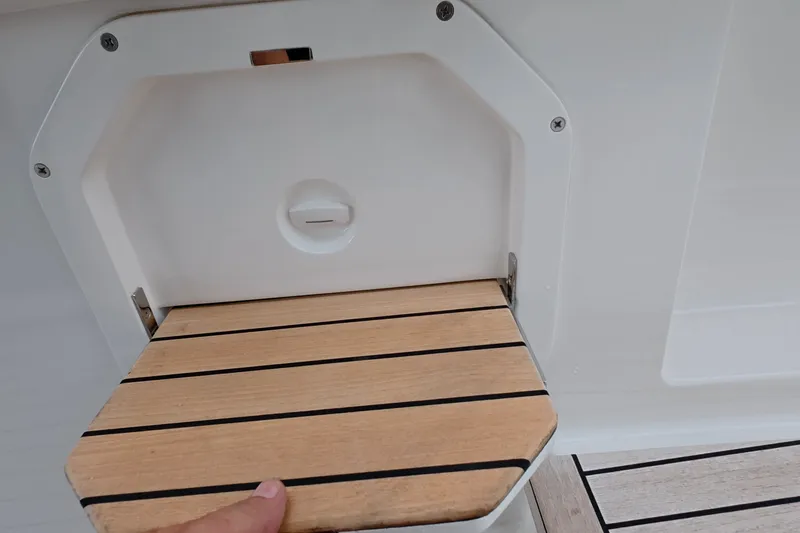 Slide: The Image of Schaefer V44 2025 boat detail with wooden fold-out step and white panel. - 38