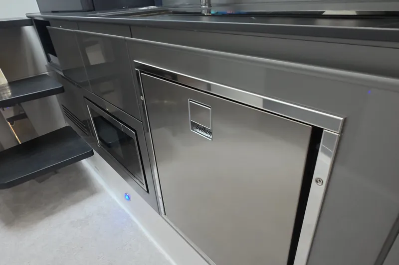 Slide: The Image of Modern interior of Schaefer V44 yacht, featuring sleek cabinetry and stainless steel appliances, 2025 model. - 46