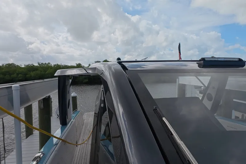 Slide: The Image of 2025 Schaefer V44 yacht docked by a serene river under a cloudy sky. - 55