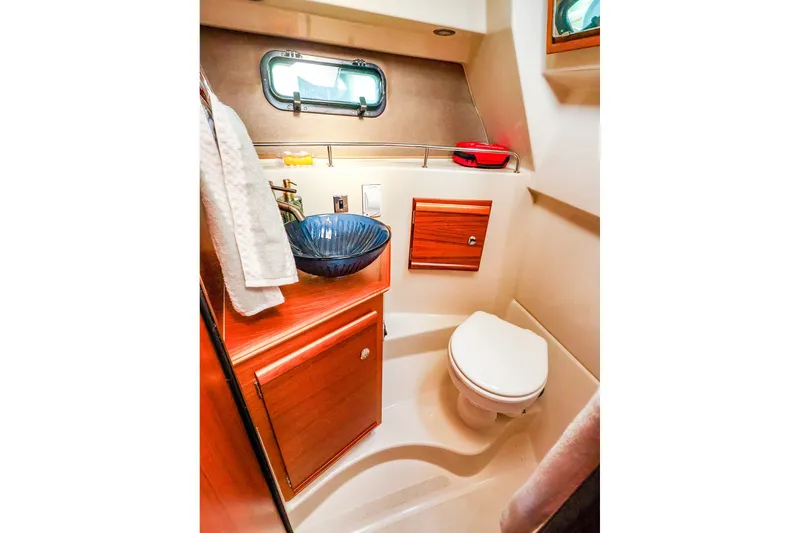 Slide: The Image of 2023 Ranger Tugs R-27 boat bathroom with modern sink and wooden cabinetry. - 44
