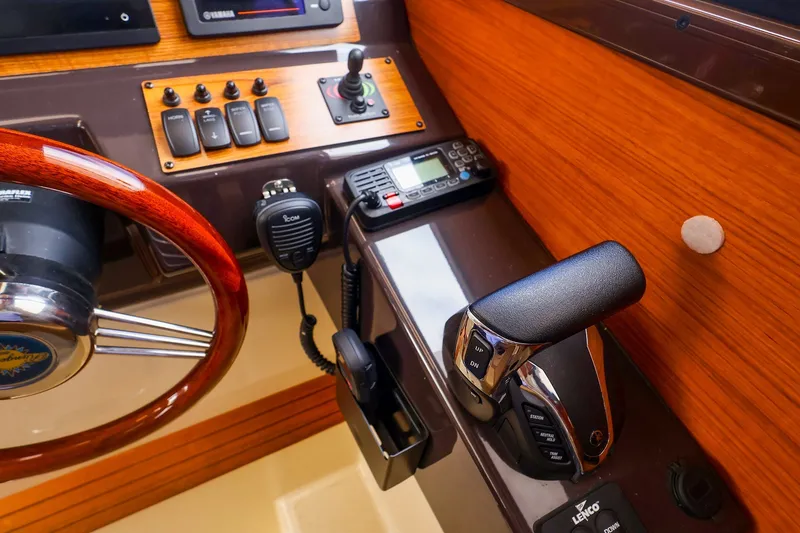 Slide: The Image of 2023 Ranger Tugs R-27 helm with steering wheel, controls, and communication equipment. - 28