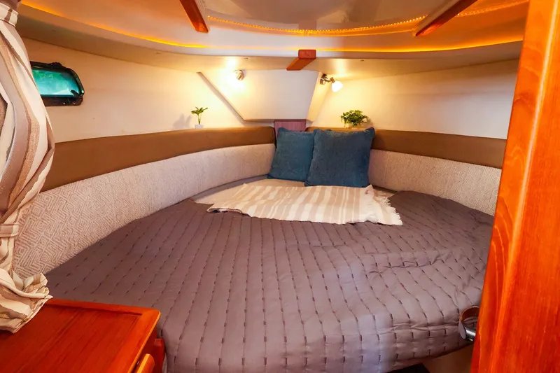 Slide: The Image of Cozy cabin interior of 2023 Ranger Tugs R-27 with plush bedding and ambient lighting. - 40