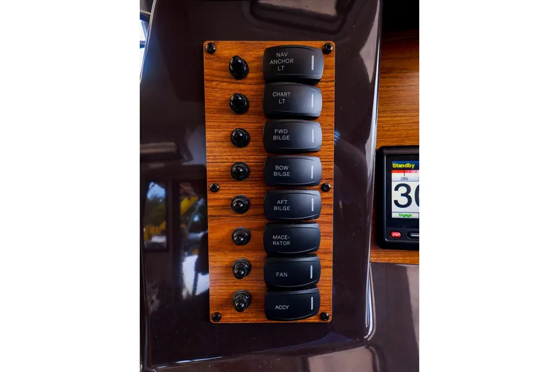 Slide: The Image of Control panel of 2023 Ranger Tugs R-27 boat with labeled switches and display. - 32