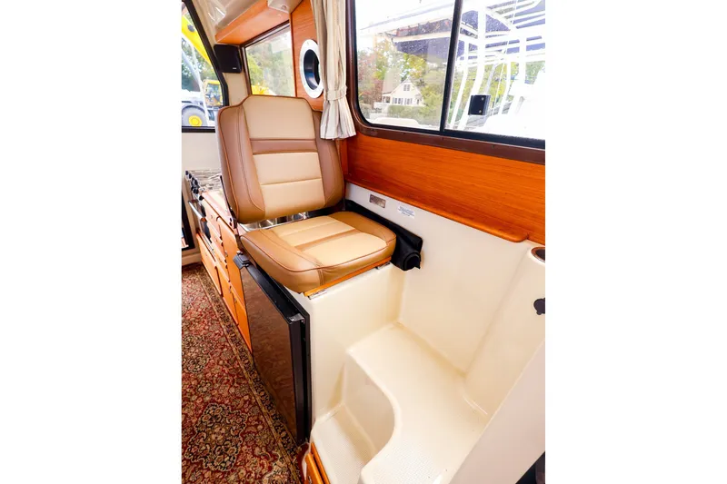 Slide: The Image of Interior of 2023 Ranger Tugs R-27, featuring a comfortable leather seat and wooden accents. - 33