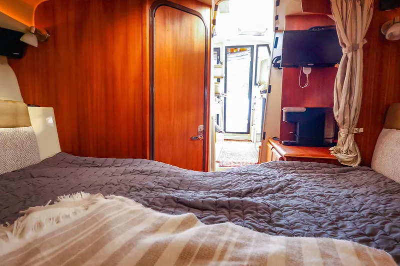 Slide: The Image of Cozy cabin interior of 2023 Ranger Tugs R-27 with bed, TV, and wooden finish. - 41