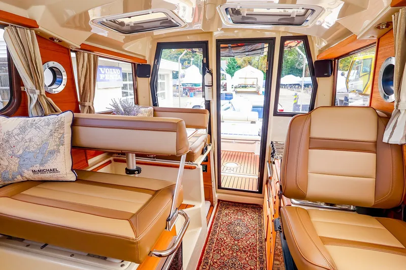 Slide: The Image of Interior of 2023 Ranger Tugs R-27 boat, featuring luxurious seating and elegant wood finishes. - 18